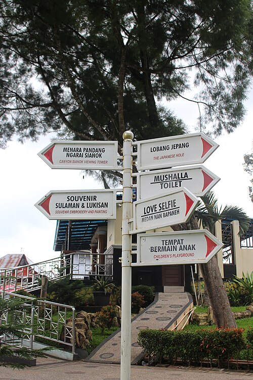 Papan petunjuk fasilitas di Ngarai Sianok menuju menara pandang, Lubang Japang, mushala, toilet, suvenir, dan tempat bermain anak